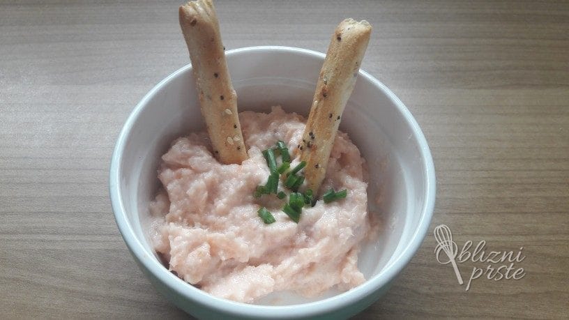 Dimljenega lososa jaz obožujem, saj ga dostikrat jem na kruhu. Že nekaj časa pa razmišljam o namazu oz. lososovi pašteti. Zadnjič sem ga naredila iz dimljenega lososa, mehkega kozjega sira in kozjega jogurta. Nastali namaz je bil zelo dober, samo za moj okus preslan, zato sem v drugem poizkusu mehak sir izpustila. Za dodaten okus sem namazu dodala še žlico limoninega soka. Namaz je narejen zelo hitro, tako je odlična predjed za nenapovedane goste. Lahko ga ponudite na krekerjih ali na kruhu. Tisti gostje, ki imajo radi lososa, bodo gotovo navdušeni. Namaz iz dimljenega lososa Pripomočki za namaz iz lososa: tehtnica žlica sekljalnik ožemalnik nož Sestavine za namaz iz lososa: 100 g dimljenega lososa 40 g kozjega jogurta (lahko tudi navadni jogurt ali kisla smetana) 3 vejice drobnjaka za dekoracijo 1 žlica limoninega soka po želji lahko dodate še 10 g mehkega sira (jaz sem ta del izpustila, ker se mi je zdelo preslano) Kako naredim namaz iz lososa: Limono prerežem in jo ožamem ter prihranim 1 žlico njenega soka. V mešalno posodo sekljalnika dam 1 zavoj (100 g dimljenega lososa) in cca. 2 žlici (40 g) kozjega jogurta. Kdor ne uživa kozjih izdelkov, lahko to nadomesti z navadnim jogurtom ali kislo smetano. Ko sem prvič delala namaz, sem poleg jogurta dodala še mehak kozji sir, samo ker sta sir in losos preslana za moj okus, sem tokrat sir izpustila. Vse skupaj zmešam z mešalnikom, da nastane gladek roza namaz. Namaz iz dimljenega lososa Lososov namaz sem za dekoracijo posula še z drobnjakom. Namaz iz dimljenega lososa Dober tek! Lososov namaz lahko namažete tudi na domač pirin kruh s semeni brez gnetenja ali na sezamove krekerje. Tukaj je še nekaj idej za namaze, ki jih lahko uporabite kot predjed: